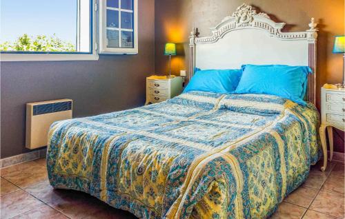 a bedroom with a large bed with a blue comforter at Gorgeous Home In Milhaud With Swimming Pool in Milhaud