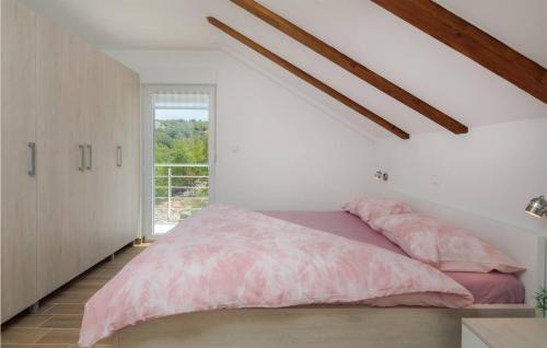 ein Schlafzimmer mit einem rosa Bett und einem Fenster in der Unterkunft 5 Bedroom Stunning Home In Zatoglav in Ražanj