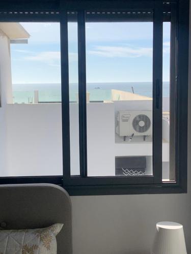 a room with a window with a view of the ocean at Belle appartement situé à la plage mahdia in Kenitra