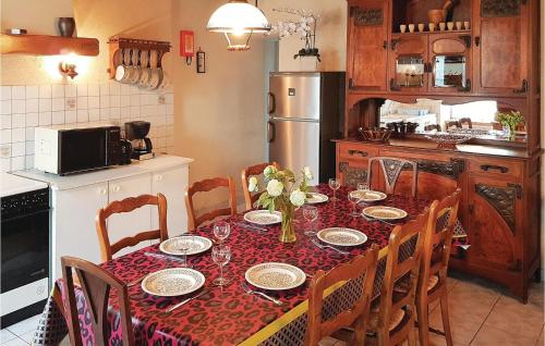 Una cocina con una mesa con un mantel rojo encima. en Holiday Home Rue Du Calvaire, en Le Cloître-Saint-Thégonnec