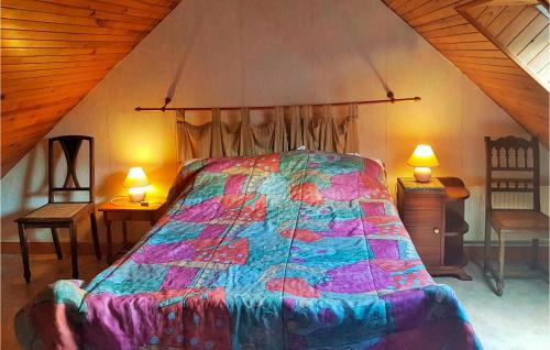 a bedroom with a bed with a colorful comforter at Beautiful Home In Le Cloitre S Thegonnec With Kitchen in Le Cloître-Saint-Thégonnec