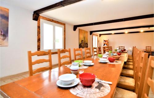 une salle à manger avec une longue table en bois et des chaises dans l'établissement Beautiful Home In Méjannes-Le-Clap, à Méjannes-le-Clap