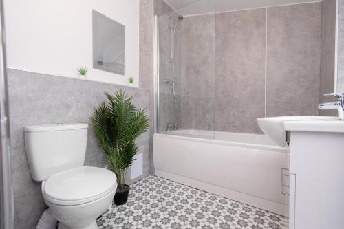 een badkamer met een toilet, een wastafel en een bad bij Great location Private Parking Contractor Leisure in Rugby