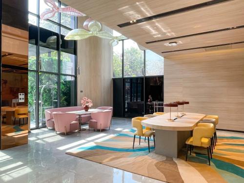 a lobby with tables and chairs and windows at Capri by Fraser, Phnom Penh in Phnom Penh