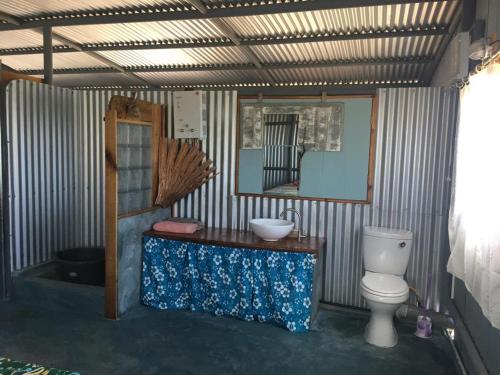 a bathroom with a toilet and a sink and a mirror at L'Arche in Rodrigues Island