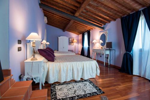 a bedroom with a large bed with blue walls at Il Casale Relais in San Giuliano Terme