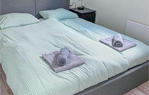 Una cama con dos pares de zapatillas y toallas. en Aqualiving Kempers, en Aalsmeer