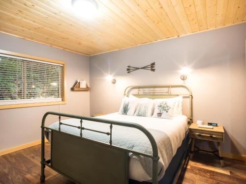 1 dormitorio con cama y techo de madera en Silver Peak Lodge, en Glacier