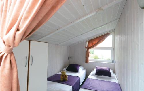 two beds in a small room with a window at Strandblick 18 in Schönhagen