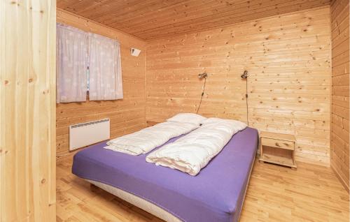 Bett in einem Zimmer mit einer Holzwand in der Unterkunft 3 Bedroom Amazing Home In Fjrland in Fjærland