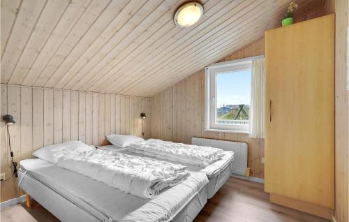 a large bed in a room with a window at Stunning Home In Hvide Sande With 4 Bedrooms, Sauna And Wifi in Bjerregård