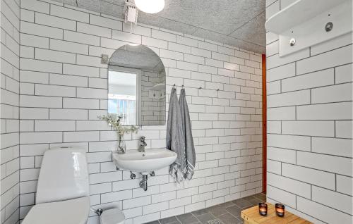 a white bathroom with a sink and a mirror at Amazing Home In Thisted With Sauna, Wifi And Outdoor Swimming Pool in Klitmøller