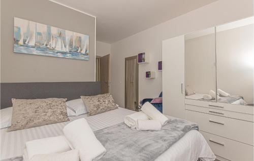 een slaapkamer met een groot bed en 2 witte stoelen bij Beautiful Apartment In Sibenik With Jacuzzi in Šibenik