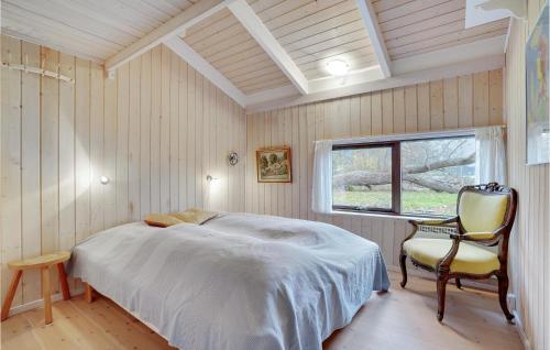 VejbyにあるBeautiful Home In Vejby With 3 Bedrooms, Sauna And Wifiのベッドルーム1室(ベッド1台、椅子、窓付)