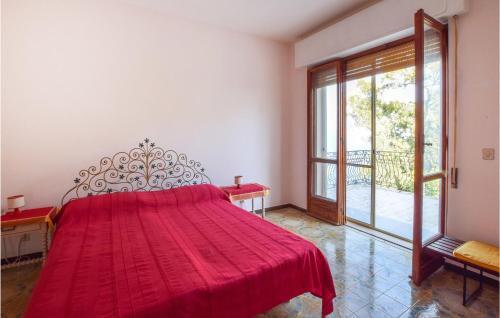 Cama roja en habitación con ventana grande en Villa Delia, en Stalettì