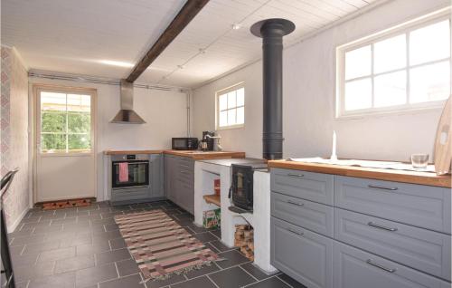 a kitchen with gray cabinets and a stove at Nice Home In Långserud With Sauna in Rullan