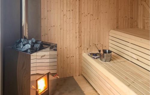 a sauna with a heater and a fire in it at Nice Home In Långserud With Sauna in Rullan