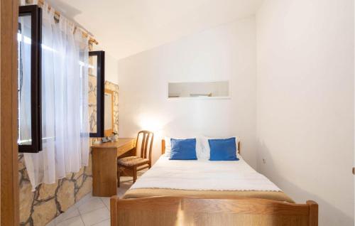 um quarto com uma cama com almofadas azuis e uma secretária em Gorgeous Home In Rukavac With Wifi em Rukavac
