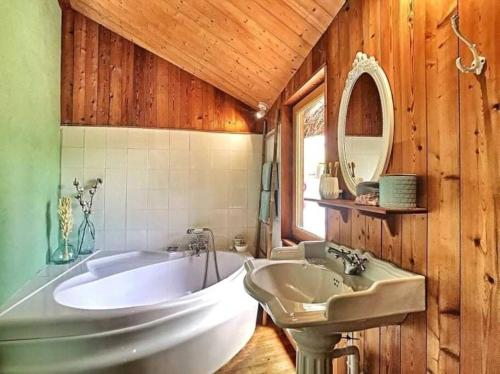 une salle de bain avec une baignoire et un lavabo dans l'établissement La cabane du bonheur, à Saint-Simon