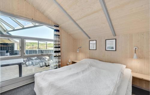 1 dormitorio con cama y ventana grande en Stunning Home In Hvide Sande With Kitchen, en Bjerregård