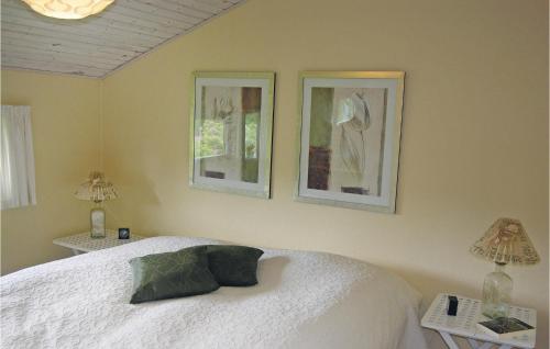 1 dormitorio con 1 cama blanca y 3 cuadros en la pared en Martex, en Fanø