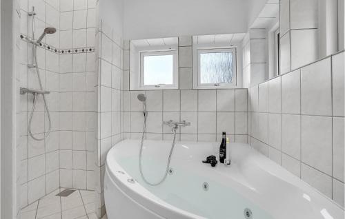y baño blanco con bañera y ducha. en Nice Home In Frvang With Wifi, en Fårvang