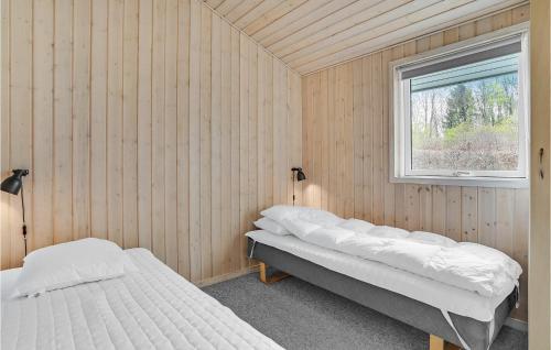 two beds in a room with a window at Nice Home In Fårvang With Sauna in Fårvang