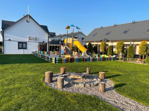 a playground with a slide in a yard at Amelia Domki in Sianozety