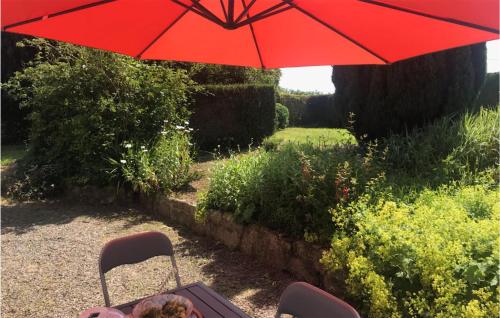 a red umbrella over a table and two chairs at 3 Bedroom Beautiful Home In Lanvellec in Lanvellec