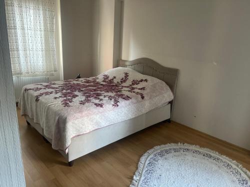 a bedroom with a bed and a rug and a window at Site Daire in Istanbul