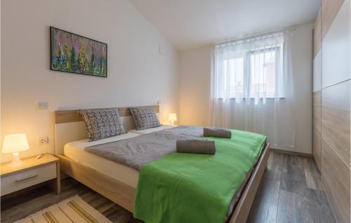 a bedroom with a bed with a green blanket at Nice Home In Barbariga With 3 Bedrooms, Wifi And Jacuzzi in Barbariga