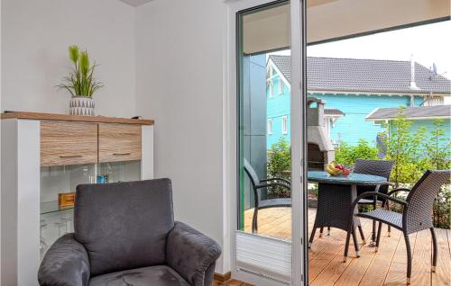 un salon avec une chaise et une table sur un balcon dans l'établissement Seewolke 4, à Süssau