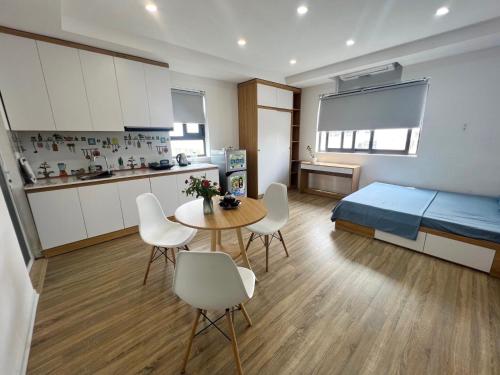 1 dormitorio con 1 cama, mesa y sillas en Nhà Như Ngọc/NN serviced apartment, en Hanói