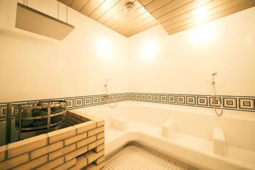 La salle de bains est pourvue d'une grande baignoire. dans l'établissement Sauna & Cabin Thermae-yu Nishiazabu, à Tokyo