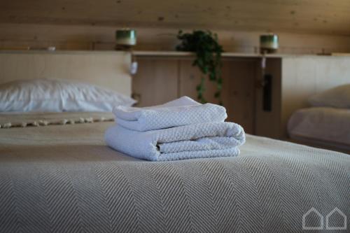 una pila de toallas sentadas encima de una cama en Nad Poziomem, 