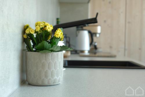 un jarrón con flores amarillas en un mostrador en una cocina en Nad Poziomem, 