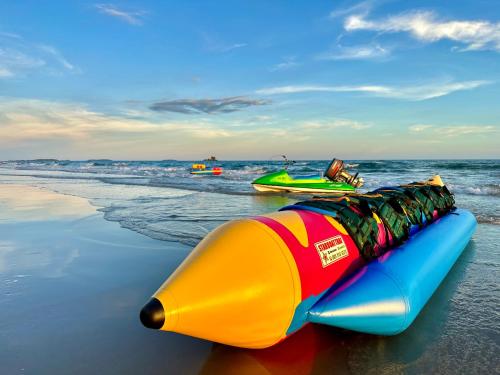 a colorful inflatable boat sitting on the beach at Escape Condominiums Beachfront Suites - Mae Phim in Rayong