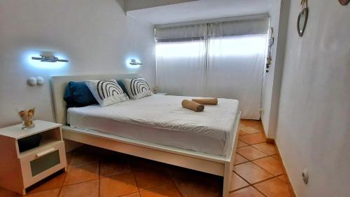 a small bedroom with a white bed and a window at El Mar in San Agustin