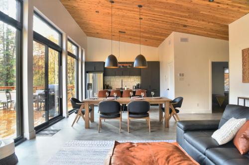 a dining room and living room with a wooden ceiling at KALLM-Mont-Tremblant chalet with hot tub, pond & beach on private 7acre estate in Lac-Superieur