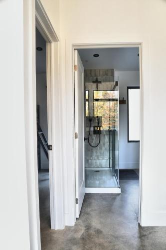 a hallway with a glass door leading to a bathroom at KALLM-Mont-Tremblant chalet with hot tub, pond & beach on private 7acre estate in Lac-Superieur
