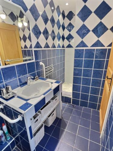 La salle de bains est pourvue de murs carrelés bleus et blancs et d'un lavabo. dans l'établissement CALADO by K6 Conciergerie, à Cassis