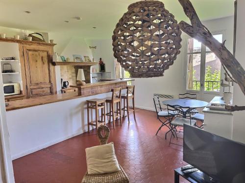 une cuisine avec une table et des chaises ainsi qu'un lustre dans l'établissement CALADO by K6 Conciergerie, à Cassis