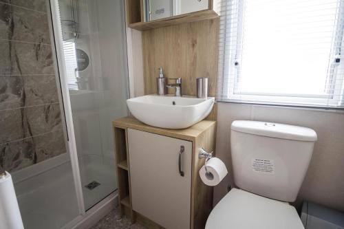 y baño con lavabo, aseo y ducha. en Beautiful 6 Berth Caravan With Decking At Southview Holiday Park Ref 33024o en Skegness