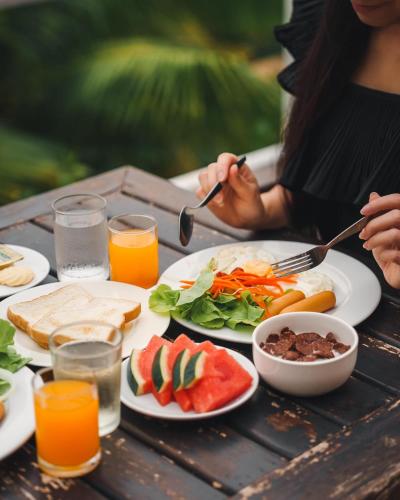 een vrouw aan een tafel met borden eten bij Kooncharaburi Resort - Koh Chang in Ko Chang