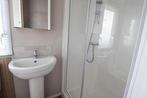 a bathroom with a toilet and a sink and a shower at Beautiful 6 Berth Caravan, Nearby Beach In Suffolk Ref 68016bs in Lowestoft