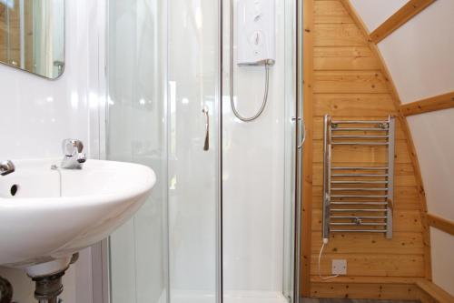 a bathroom with a sink and a shower at LOCH TAY HIGHLAND LODGES and GLAMPING PARK in Morenish