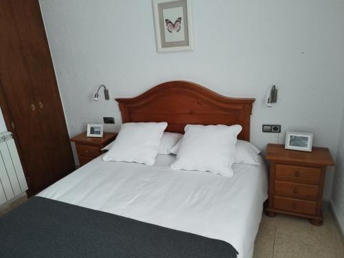 1 dormitorio con 1 cama con sábanas y almohadas blancas en CAL JAN - SOLANA en Bellver de Cerdanya 