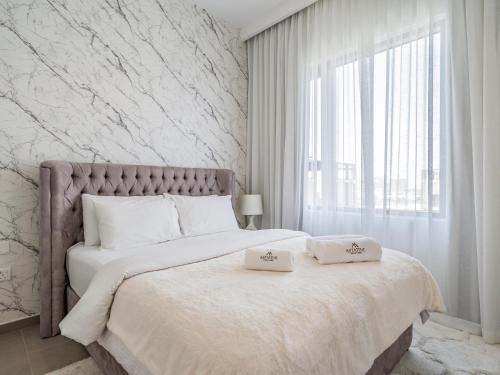 a bedroom with a large bed with two pillows on it at Chic 1BR in Park Heights 2 - Dubai Hills in Dubai