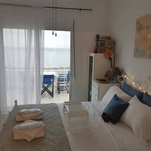 a bedroom with a bed and a table and a dining room at Seafront Aegean Νest in Karpathos