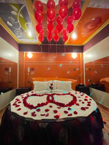 a bedroom with a bed with red balloons on the ceiling at Hotel Manantial No,001 in Lima